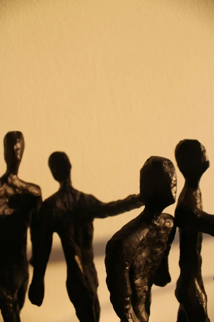 a group of bronze figurines holding hands